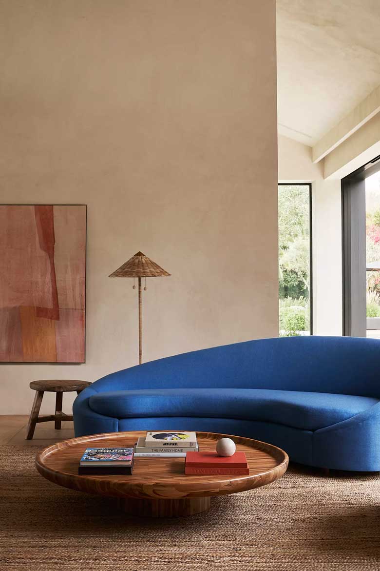  Teak wood coffee table paired with a blue curved sofa, perfect for a modern living room